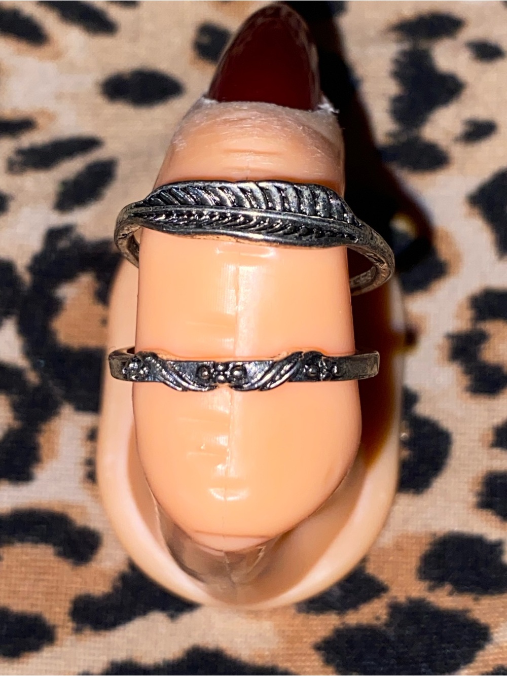 Silver ring with feather design and another ring with a sort of wing design